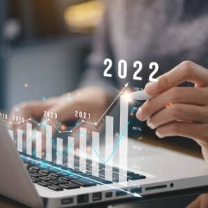Analyzing growth: business professional reviewing digital marketing trends in a multi-year financial performance chart superimposed over a laptop screen, highlighting positive trends through 2022.